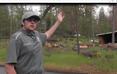 Michael Beaudoin from the Mariposa County Fire Safe Council in front of a home surrounded by dead trees.